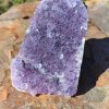Amethyst statement piece with rich purple crystal formations and natural purple tones displayed on a rock.