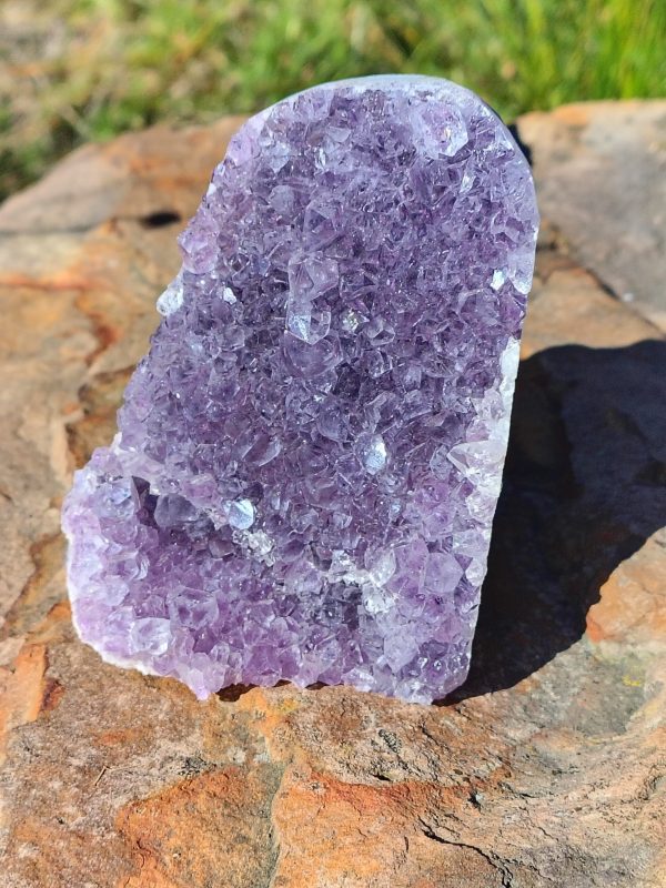 Amethyst statement piece with rich purple crystal formations and natural purple tones displayed on a rock.