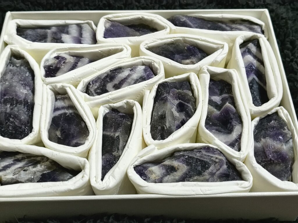 Raw Dream Amethyst crystal held in a hand, showing its natural purple tones and unique crystal formations.