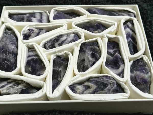 Raw Dream Amethyst crystal held in a hand, showing its natural purple tones and unique crystal formations.
